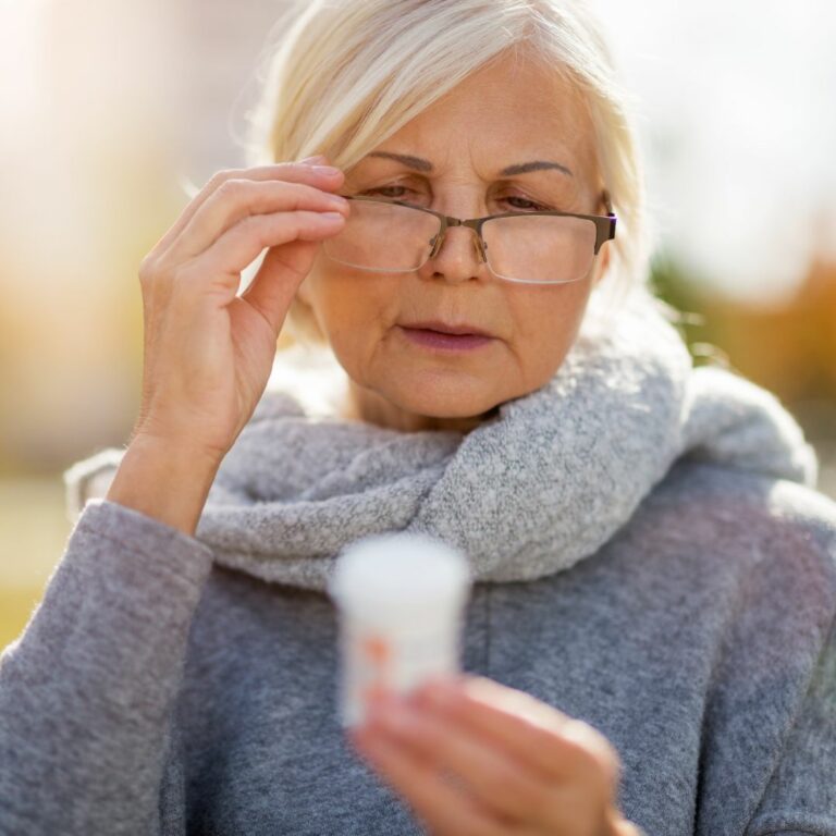 Older woman lowering glasses to read small print