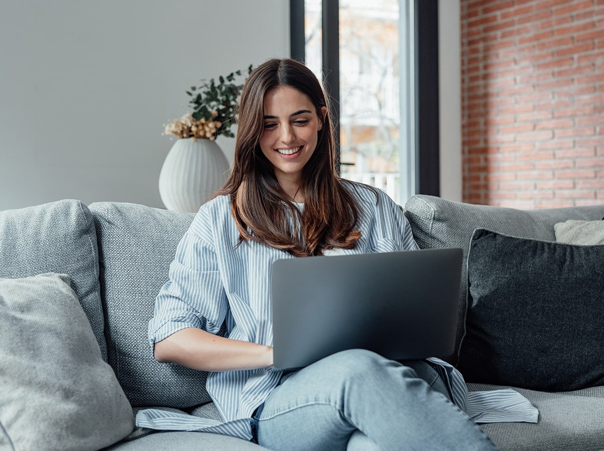 Woman sitting on a couch with her laptop